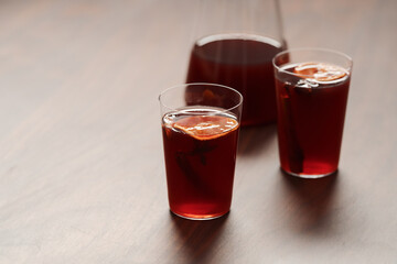 Mulled wine in tumbler glasses on walnut table with copy space