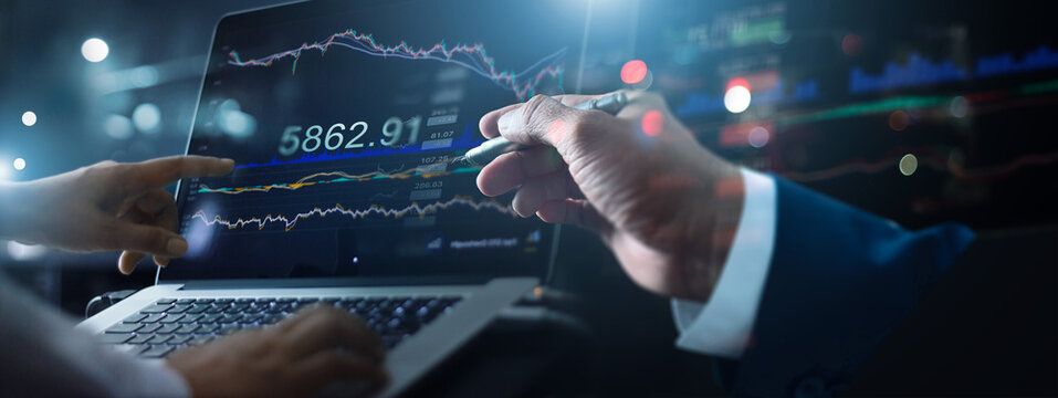 Business team working together. Businessman using laptop for analyzing data stock market in monitoring with team pointing on the data growth presented in the chart, Stock chart and investment concept.