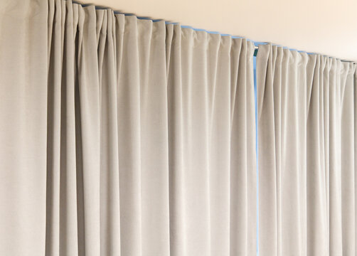 A pair of white curtains with blue trim