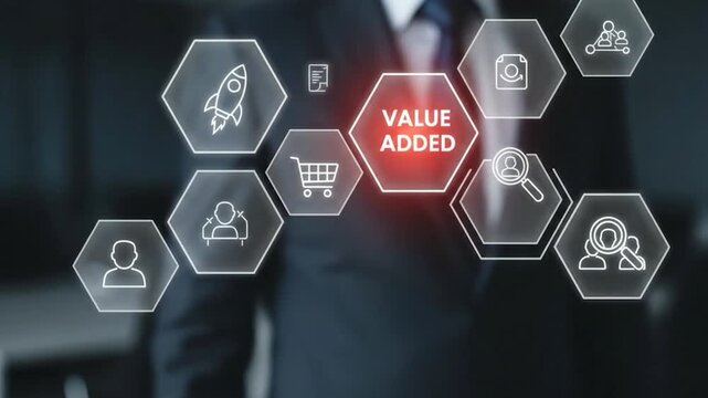 Businessman touching a glowing hexagon interface with the words value added and various business icons