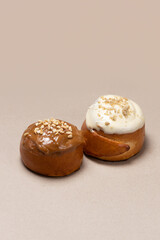 Cream-Topped Buns with Nuts on Solid Background