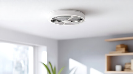 A sleek, circular ventilation system is mounted on a white ceiling. The modern design complements a minimalist, brightly lit room enhancing air quality, and overall comfort.