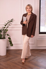 Vertical. Young businesswoman holding digital tablet. Businesswoman holding position.