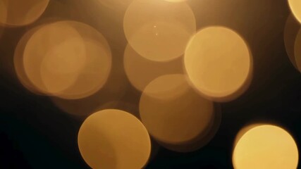 Large golden out-of-focus bokeh lights moving slowly. Abstract yellow light leak background for luxury or holiday overlays. - Powered by Adobe