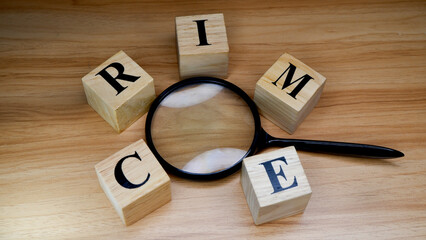 Crime investigation concept with magnifying glass and wooden blocks.