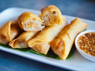 Fried spring rolls and dipping sauce on a plate. Crispy and delicious Thai food. Snack.