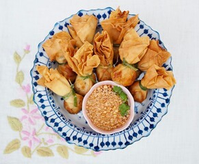 Deep fried shrimp dumplings and dipping sauce are placed on a plate. Crispy and delicious Thai food.