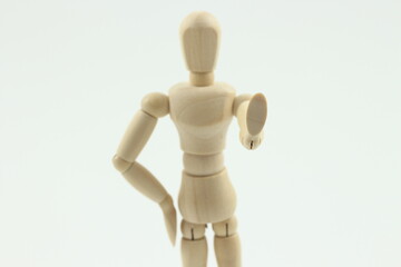 白い背景の前で静止を求める木製の人形