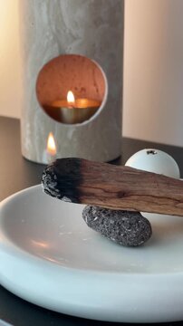 Burning incense wood for relaxation &ndash; aromatic smoke rising in cozy home interior with warm calm atmosphere

