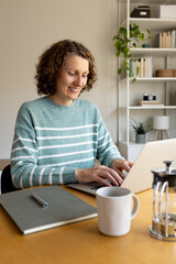 Smiling woman remote working from home on laptop