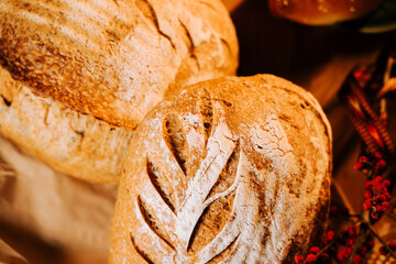 Freshly baked artisan bread with elegant leaf patterns displayed for sale