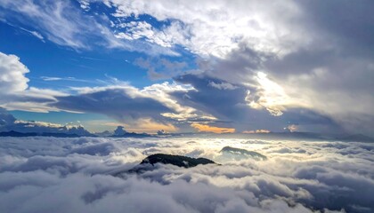 Aerial view of a mountain range enveloped in a sea of clouds under sunlight