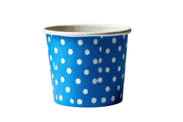 Close-up of a blue paper cup with white polka dots against a stark, black background