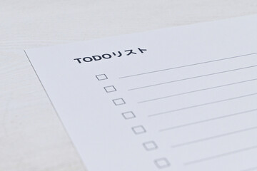 白いデスクに置かれたシンプルなToDoリスト用紙