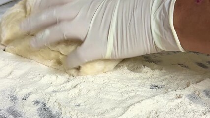 Macro shot of human hands dusting, cutting, and kneading raw yeast dough. Close-up of finished raw white flour dough. Homemade baking. - Powered by Adobe