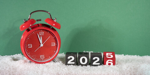 Happy new year, new year's eve celebration holiday greeting card - Alarm clock countdown and changing year in the snow, green background