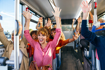 Group of excited people waving with hands up, traveling on public city transport, enjoying the ride...