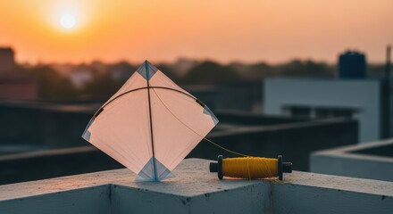 White kite and yellow string on rooftop at sunset