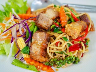 Stir-fried  spaghetti with crispy pork  on a plate. It looks so deilcious and appetizing.