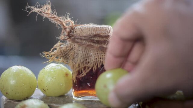 Close-up of Fresh Indian Gooseberry (Phyllanthus emblica) and Herbal Amla Oil &ndash; Ayurvedic Remedy for Hair Growth and Nutrition