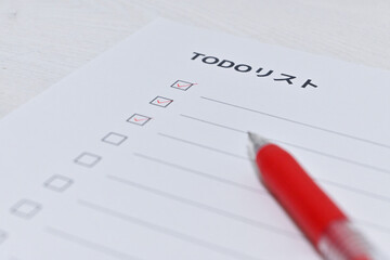 3つのタスクが完了したチェックリストと赤いボールペン