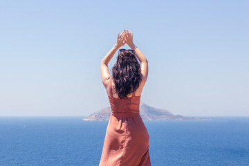 Young girl dancing on a background of blue sea and sky
