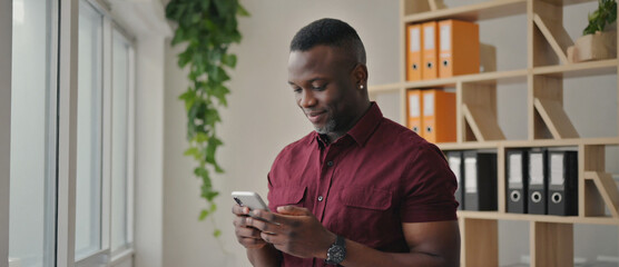 Connected in the Office: An individual, deeply engaged with his smartphone, finds connectivity within the modern office environment. Reflecting technological integration and everyday life.