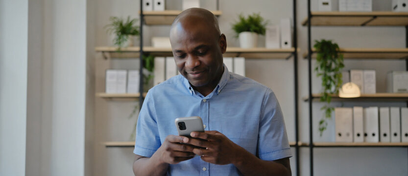 Modern Communication: An individual engrossed in the digital realm, his focus riveted to his handheld device. The contemporary setting subtly underscores the ubiquity of modern communication.