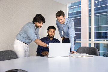 Multiethnic diverse male business team talk at workplace using notebook