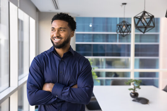 Smiling Black man entrepreneur look at window in office boardroom