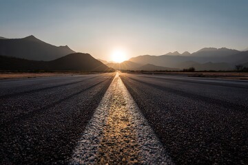 Road Leading to Horizon with Mountains at Golden Sunset Hour Sunlight Over Asphalt Road with Center Line Marking