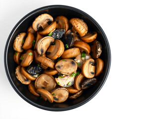 Fototapeta premium Sliced Mushrooms in a Black Bowl on White Background