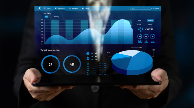 Business professional holds a tablet featuring digital displays of charts and graphs, analyzing key performance metrics and activity data for informed decision-making. Impute