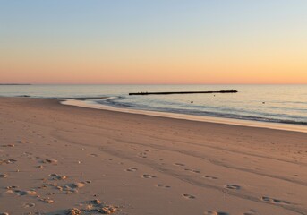 Horizon line meets sandy shore during tranquil twilight hours