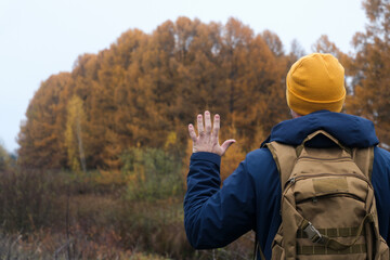 Hiker making salute in autumn forest