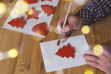 Man painting handmade christmas decorations for holiday craft