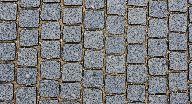 Close-up view of a textured cobblestone street surface, showcasing the intricate pattern and rough texture of the individual stones.