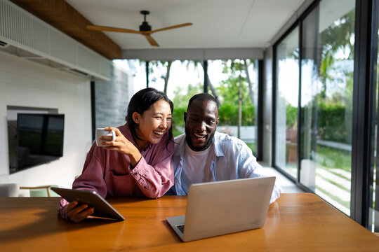 Digital lifestyle, online connectivity. Diverse couple enjoying entertainment shopping with laptop