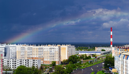 Fantastic beautiful rainbow over city buildings after rain