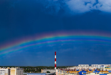 Fantastic beautiful rainbow over city buildings after rain