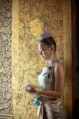 Beautiful young Asian woman in traditional Thai Dusit dress in an old temple in Chiang Mai, Thailand.