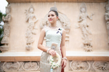 Beautiful young Asian woman in traditional Thai Dusit dress in an old temple in Chiang Mai, Thailand.