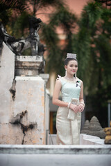 Beautiful young Asian woman in traditional Thai Dusit dress in an old temple in Chiang Mai, Thailand.