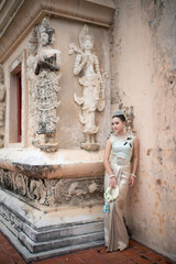 Beautiful young Asian woman in traditional Thai Dusit dress in an old temple in Chiang Mai, Thailand.