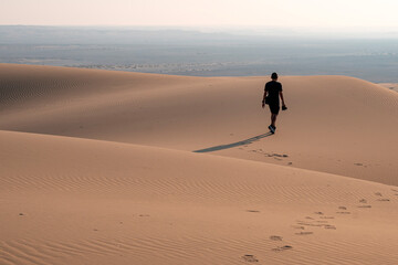 Doha, Qatar - October 30, 2025: man walking in the desert. Singing dune Qatar