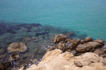 turquoise sea background. top view of rocky sea shore. natural color contrast. beige rocky texture. minimalist seascape with clear transparent
