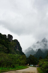 Small rural village surrounded by misty limestone mountains and jungle, Vang Vieng, Laos