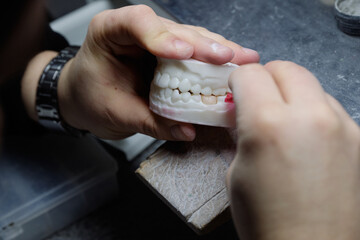 Close-up of a specialist performing accurate grinding on a high-tech dental mock-up.