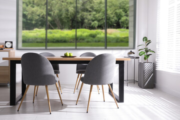 Table and chairs near window in room. Interior design