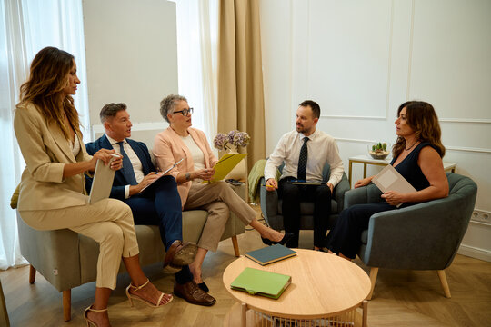 Business professionals discussing strategy during informal office meeting